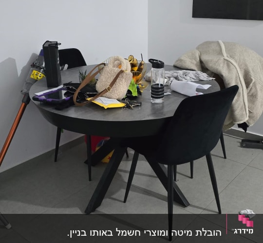 שולחן עם חפצים שונים, כולל תיק ובקבוק מים